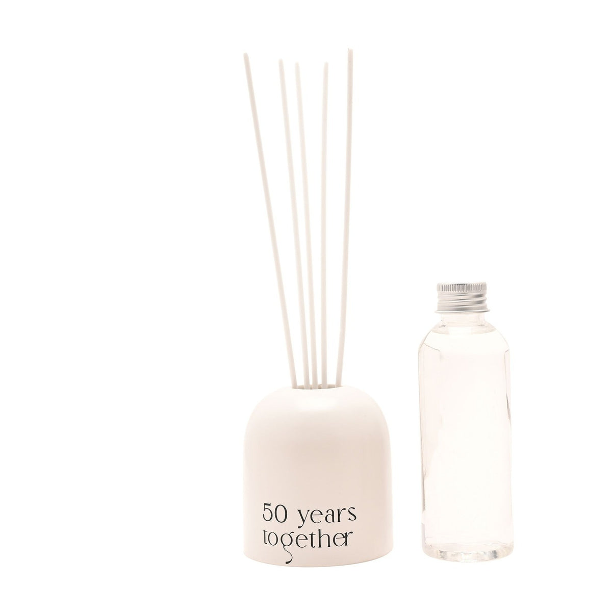 Beige glass reed diffuser with arched, dome-topped holder reading "50 years together", fitted with upright white reeds, beside a clear refill bottle on a white background.