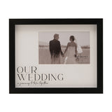 Black plastic 6 x 4in photo frame with woodgrain-effect edges, white mount reading "Our Wedding, a journey to take together", shown with a wedding couple photo on a white background.