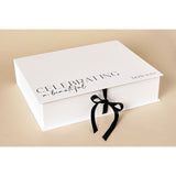 White A4 rectangular keepsake box with black "Celebrating a beautiful bride to be" text on lid, closed with a black ribbon tie, set on a neutral background.