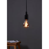 Amber Dimmable LED Bulb E27, A-shape glass with visible filaments, glowing warm white in a black pendant fitting against a dark grey wall.
