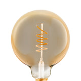 Amber-tinted LED globe bulb (G125, E27) with a spiral filament on a slim glass stem, brass-coloured screw cap, shown close-up against a plain white background.