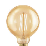Close-up of an amber glass G95 LED globe bulb with E27 screw cap, showing upright crossed filaments, dimmable, warm white, on a plain white background.