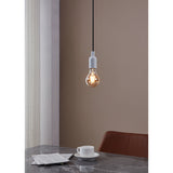 Amber LED Bulb E27, A-shaped glass bulb with visible filaments, shown lit in a white pendant fitting above a dining table in a warm-toned room.
