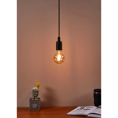 Pendant light fitted with an amber LED globe bulb, E27 fitting, glowing warm white above a desk with a cactus, mug, and open book.