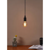 Amber LED Globe Bulb E27 G80 8W warm white, shown lit in a matte black pendant fitting above a desk with a cactus, camera lens, and open book.