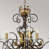 Introducing the Amarilli 5 Light Chandelier by Elstead Lighting, a stunning creation with intricate bronze scrollwork and a gold patina, highlighted by candle-like lights housed in clear glass holders. This ornate design stands elegantly against a light grey background.