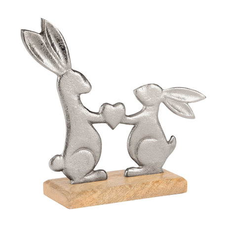 Amoatsy Rabbit Ornament 21cm in silver aluminium, showing two rabbits holding a heart between their paws, mounted on a natural mango wood base against a white background.