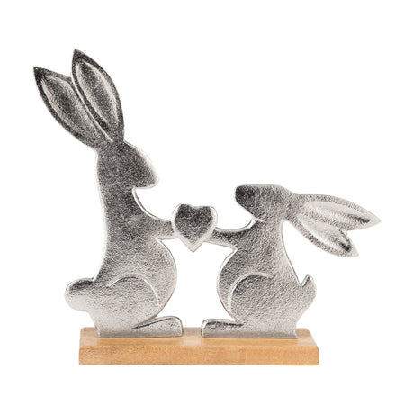 Amoatsy Rabbit Ornament 28.5cm – flat cut-out silver aluminium rabbits holding a heart, textured finish, on a natural mango wood base, shown on a white background.