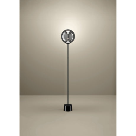 Anorias LED Floor Lamp in black nickel, featuring a slim steel stem, round base, and smoked glass globe shade, shown glowing against a plain neutral background.