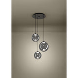 Anorias 3-light pendant with three smoked glass globes of varying sizes on black nickel cords from a round ceiling canopy, shown illuminated in a plain room setting.