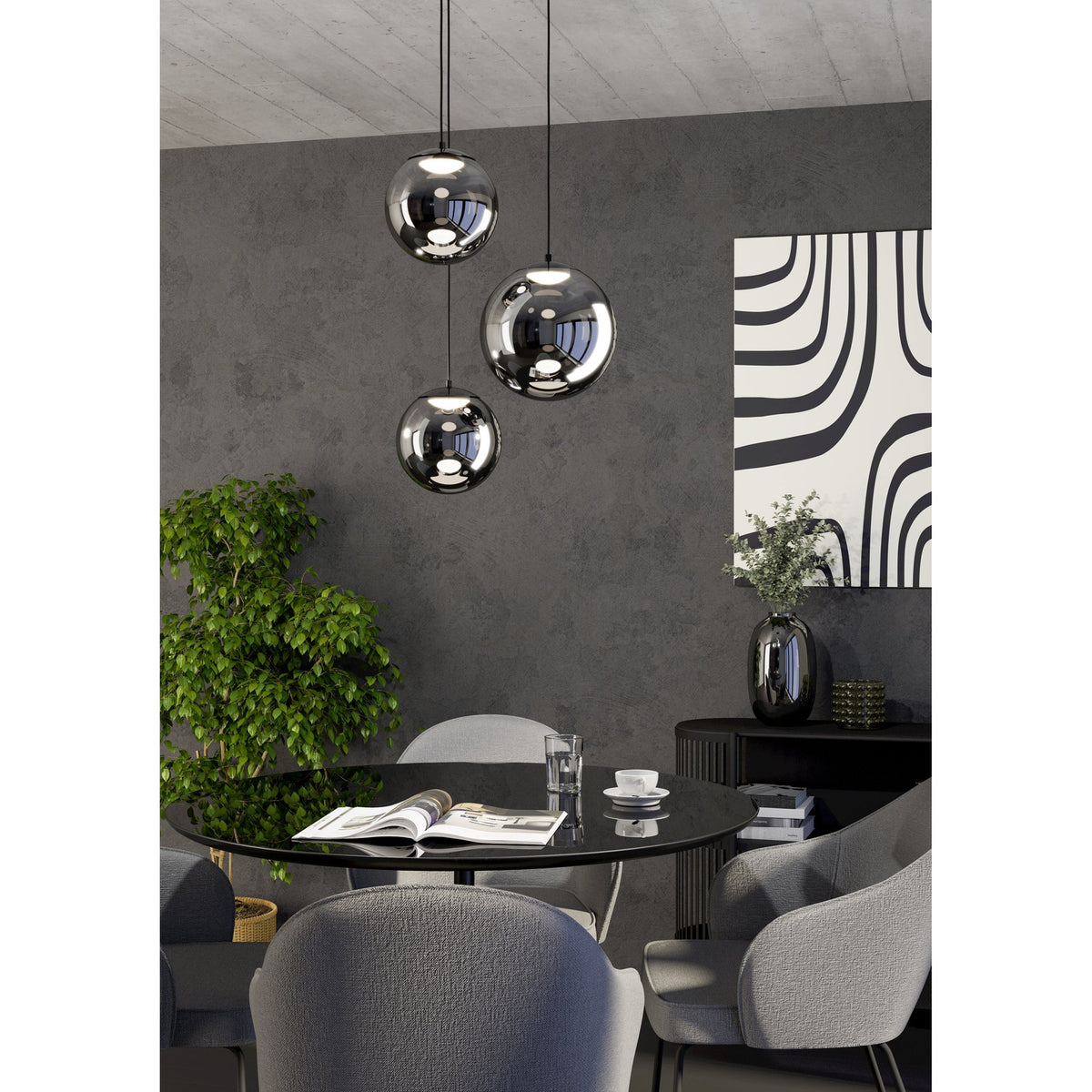 Anorias 3 light pendant with smoked glass globes of varying sizes in a black nickel finish, hanging at staggered heights above a dining table in a grey-toned dining room.