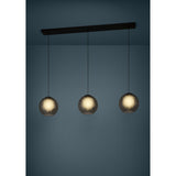 Arangona Glass Linear Pendant Light in black, three smoked grey globe shades on black cords suspended from a long black steel ceiling bar, shown illuminated against a dark blue background.