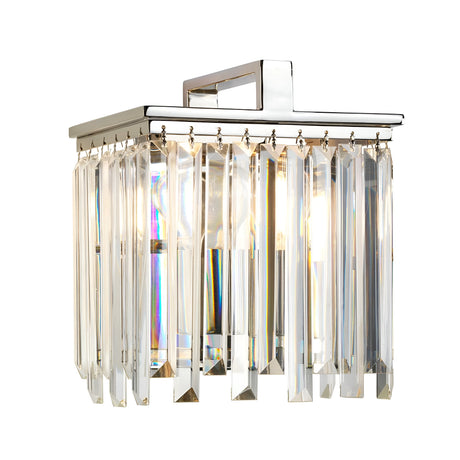 The Aries Wall Light - Polished Nickel showcases a square chrome base embellished with hanging cut glass crystals, producing a shimmering effect as light filters through them. Its refined design is highlighted by polished nickel, bringing a touch of sophistication to any space.