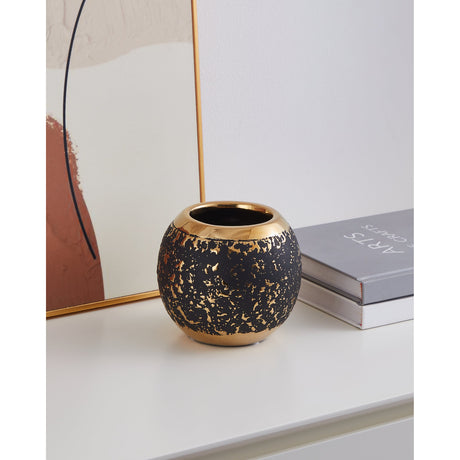 Arroyito Ceramic Vase 11cm in Black & Gold, a round, globe-shaped vase with matt black body, gold-flecked surface, gold rim and base, shown on a shelf beside books and framed art.