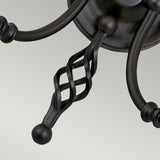 A close-up showcasing the intricate details of twisted black metal rods in a lattice design, complemented by hand-formed metal scrolls and spherical accents, describes the Artisan 2 Light Wall Light - Black. This stylish wall light seamlessly integrates into the overall structure with its sleek black finish and curved elements.