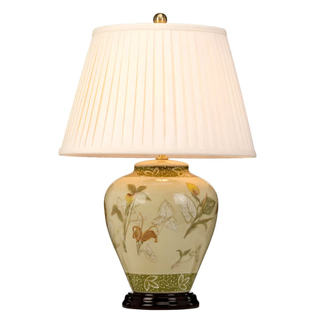 The Arum Table Lamp - Aged Brass showcases a white pleated lampshade set on an ornately decorated ceramic base, inspired by Chinese porcelain and embellished with intricate floral and leaf patterns. It boasts a glossy finish with green, yellow, and brown tones, elegantly positioned on a petite black stand.