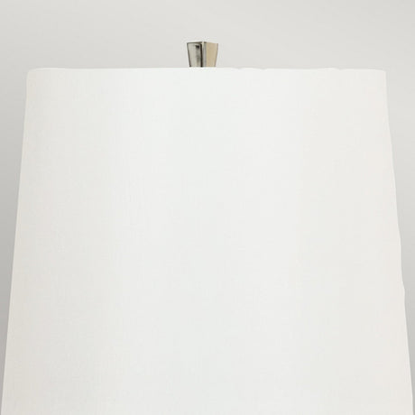 Close-up view of a sleek white lampshade, which is part of the Ascent Table Lamp - Black/White with its contemporary design. The metallic lamp post rises elegantly above the lampshade's surface. The light gray background enhances its black and white aesthetic, offering a stylishly neutral setting.