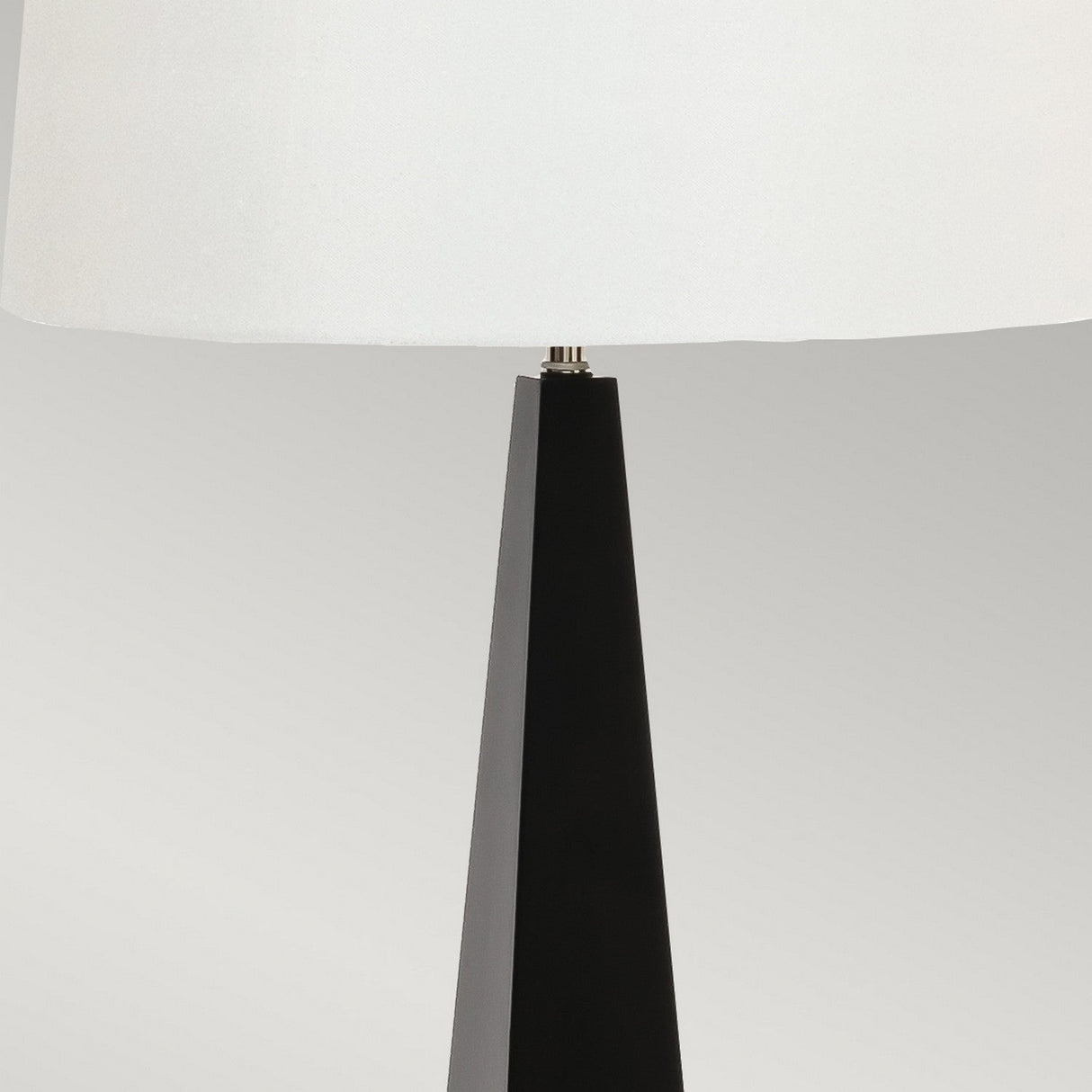 The Ascent Table Lamp - Black/White showcases a modern design with its sleek black and white colors, highlighting a tapered base and a large white lampshade set against a neutral background.