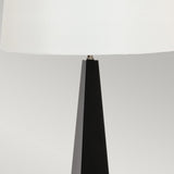 The Ascent Table Lamp - Black/White showcases a modern design with its sleek black and white colors, highlighting a tapered base and a large white lampshade set against a neutral background.