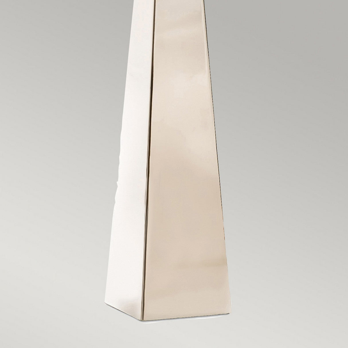 A close-up of the base of this tall, rectangular structure highlights its polished nickel finish and smooth surfaces against a neutral gray background. This striking design element shares the sleek aesthetic of contemporary pieces such as the Ascent Table Lamp With Black Shade - Polished Nickel.