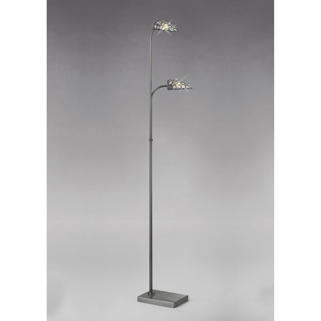 The Ashton 2 Light Crystal Floor Lamp in Satin Nickel features a square base, slim metal stand, and two upward-curving arms with crystal, leaf-inspired lights, set against a plain gray background.