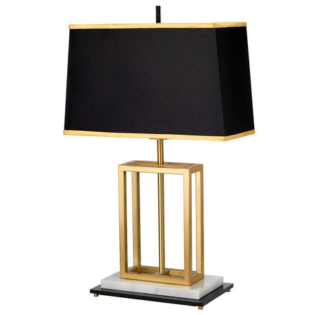 The Atlas Table Lamp - Brushed Brass features a sleek black rectangular shade accented with brushed brass trim. Its base boasts an open geometric gold frame perched on a striking marble foundation, marrying elegance with contemporary style.