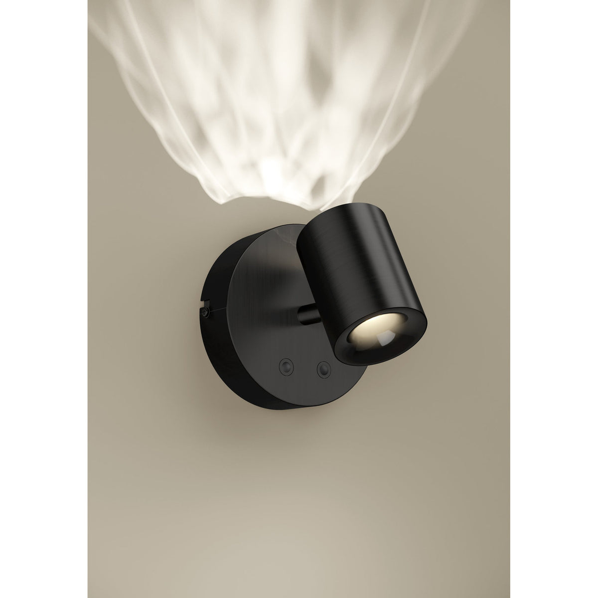 Auro LED Ceiling Light in black, round steel backplate with an angled cylindrical head, mounted on a neutral wall with a warm light beam visible above.