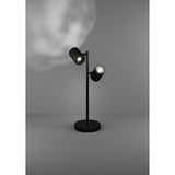Auro LED Table Lamp in black steel with two adjustable cylindrical spot heads on a slim stem and round disc base, shown lit against a grey background.