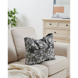 Bachuma Bag in black jungle toile print on off-white fabric, shown with twin handles on a beige sofa in a living room setting.