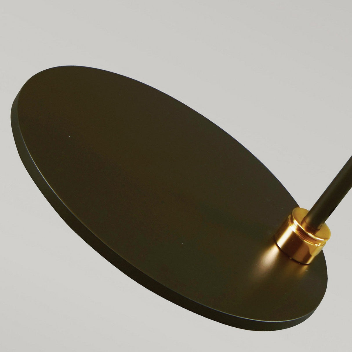 A close-up of the Balance Table Lamp in Black and Polished Brass highlights its modern design with a polished brass cylindrical connector on the side, set against a neutral background.