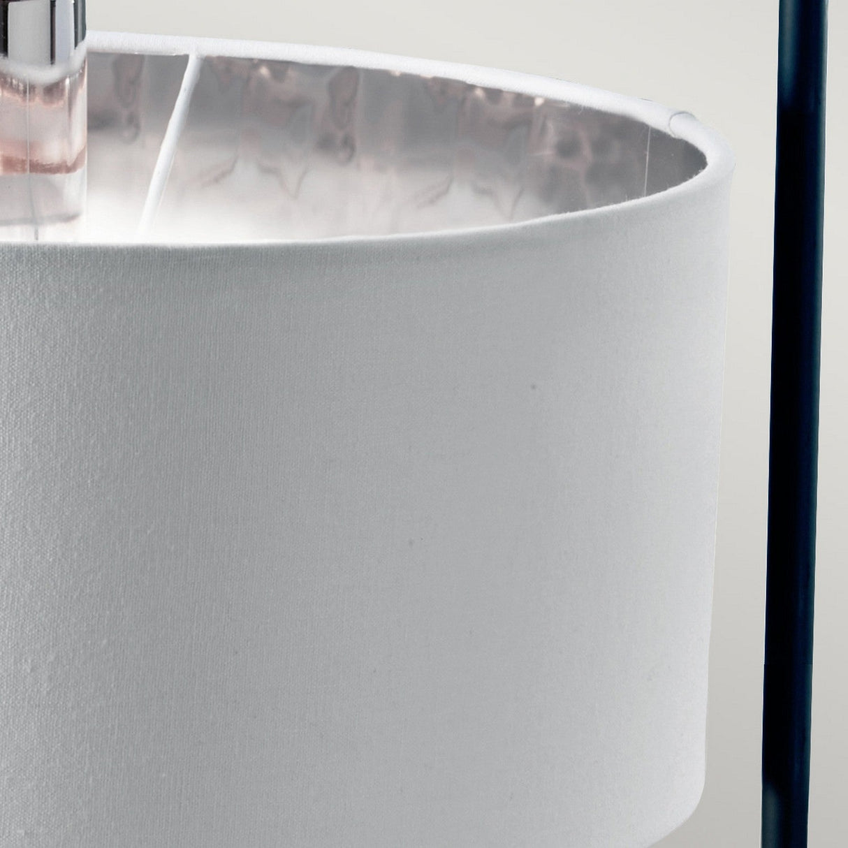 Close-up of the Balance Table Lamp - Black/Polished Nickel, featuring a white fabric shade. The interior showcases a reflective polished nickel finish, while a black vertical support pole on the right adds to its minimalist, contemporary design.