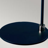 Close-up of the Balance Table Lamp - Black/Polished Nickel, featuring a sleek, modern circular metal base with a vertical rod, set against a light gray background. The design showcases a minimalist and contemporary aesthetic.