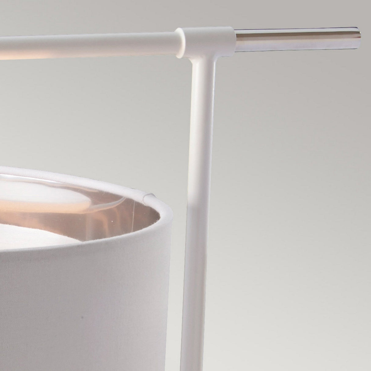 Close-up of the Balance 1 Light Table Lamp, showcasing its white fabric shade and sleek, minimalist design. It features a cylindrical frame and a horizontal metal arm in polished nickel, set against a neutral background, perfect for providing ambient light.