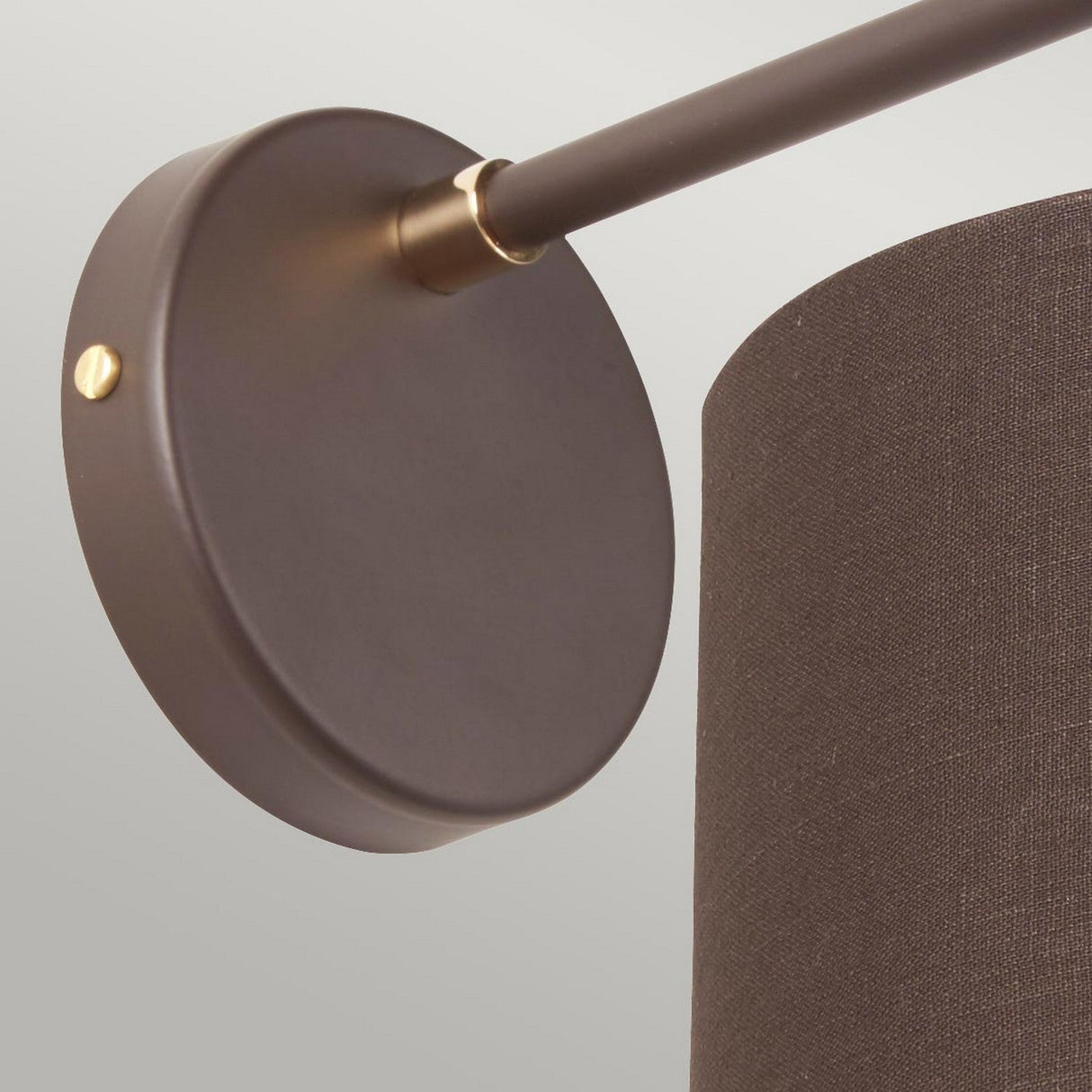 Close-up of the Balance 1 Light Wall Light in brown with polished brass accents, showcasing a Mid-Century Modern design with a circular base and cylindrical shade, set against a neutral background.