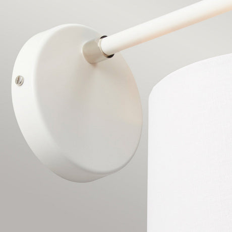 A detailed look at the Balance 1 Light Wall Light - White/Polished Nickel reveals its modern design, featuring a round white wall mount and a polished nickel extending arm that supports a cylindrical white lampshade. Set against a light gray background, this fixture enhances any space with its sleek and energy-efficient lighting design.