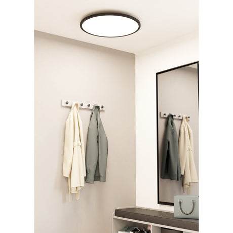 Balvena Smart LED Flush Ceiling Light, 60cm round fixture with black aluminium and steel frame and white diffuser, shown lit on a hallway ceiling above a coat rack and mirror.