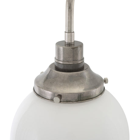 Close-up of the Bamako Glass Globe Wall Light, 20cm opal glass globe held in an antique silver gallery with knurled screws, on a bent arm against a white background.
