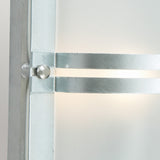 Close-up of the Basel Outdoor 1 Light Wall Lantern in silver, designed with a frosted glass panel and sleek metal structure. Its cylindrical support provides warm ambient lighting and boasts an IP54 rating, offering a contemporary and minimalistic appearance.