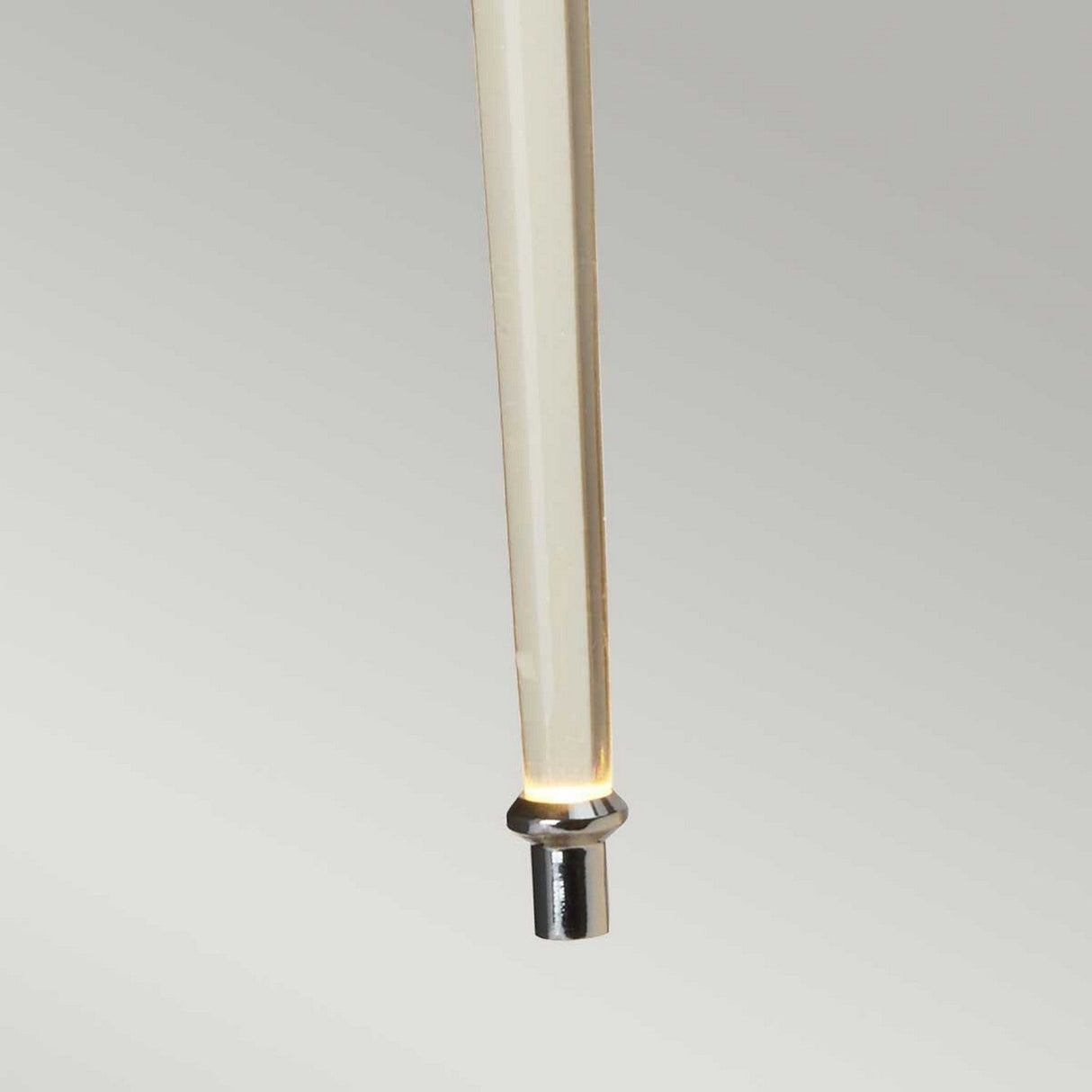 A close-up of the Agatha 2 Light Wall Light reveals its light-colored, tapered design with a metallic end tip, set against a neutral background. Its minimalistic and smooth form is enhanced by polished chrome accents, giving it a sleek and modern appearance.