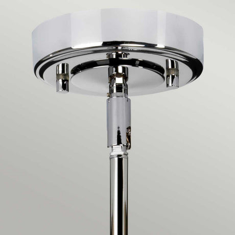 A close-up of the Agatha 1 Light Pendant - Polished Chrome showcases its sleek, modern design. Featuring a round base and a glossy finish, this ceiling light fixture effortlessly reflects light on its smooth surface, making it ideal for bathroom lighting against a neutral light grey background.
