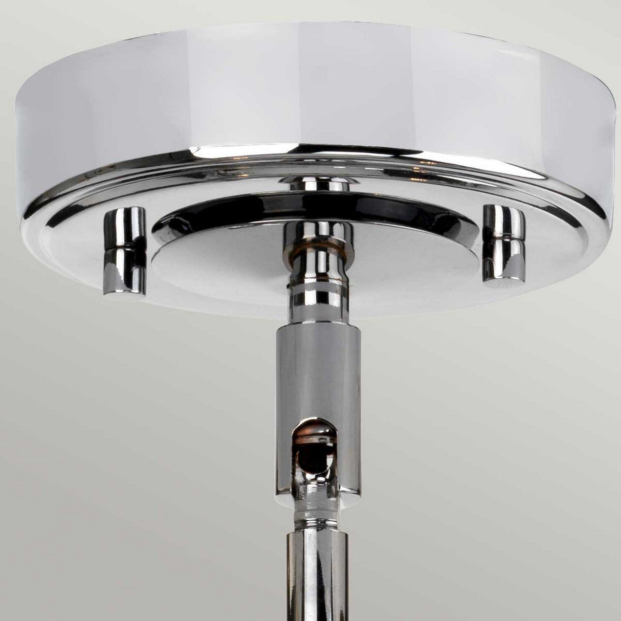 This image showcases the Agatha 3 Light Pendant in polished chrome, featuring a sleek and modern design. The pendant has a circular base that attaches to the ceiling and a central rod extending downwards, ideal for adding a light bulb or shade.