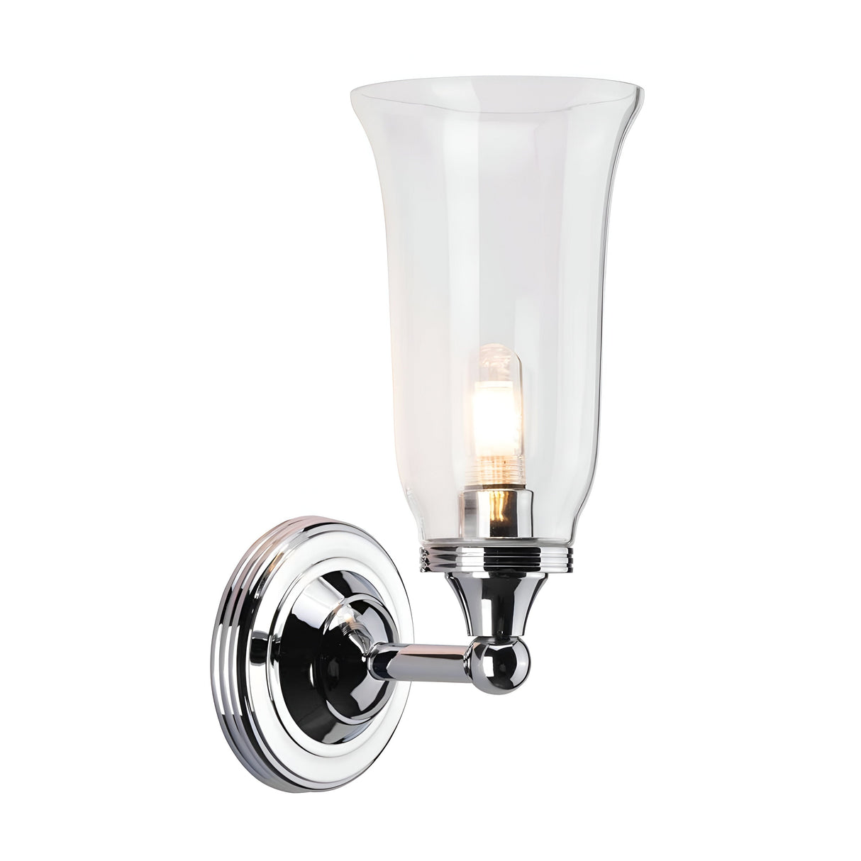 The Austen-2 Wall Light - Polished Chrome is a wall-mounted fixture that features a clear glass shade and an exposed LED G9 bulb. Its sleek design includes a circular base and curved arm, adding a modern touch to any interior decor.