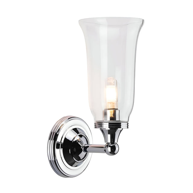 The Austen-2 Wall Light - Polished Chrome is a wall-mounted fixture that features a clear glass shade and an exposed LED G9 bulb. Its sleek design includes a circular base and curved arm, adding a modern touch to any interior decor.