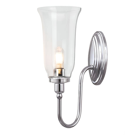 The Blake Wall Light - Polished Chrome is a wall-mounted fixture boasting a sleek, curved metal arm and a clear glass shade. Its polished chrome finish, combined with the visible LED G9 lamp inside, creates a warm glow that enhances any space.