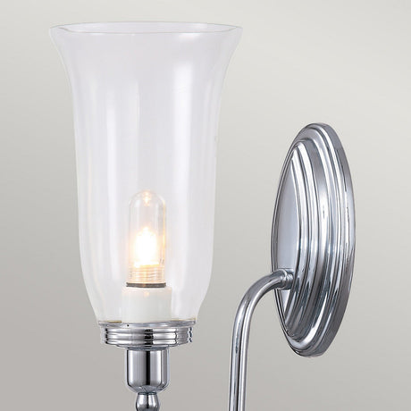 The Blake Wall Light - Polished Chrome includes a clear glass shade that showcases an LED G9 lamp within, set against a light gray background.