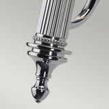 A close-up of the Carroll-1 Wall Light - Polished Chrome showcases an ornate silver metallic piece with a fluted design and decorative beading near the top. The object tapers to a rounded point at the bottom, set against a light gray background.