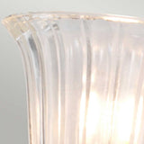 The Carroll-1 Wall Light - Polished Chrome features a translucent glass lampshade with vertical ridges, gently lit by an energy-efficient LED. Its polished chrome base contrasts stylishly with the light gray background, offering a modern touch of elegance.