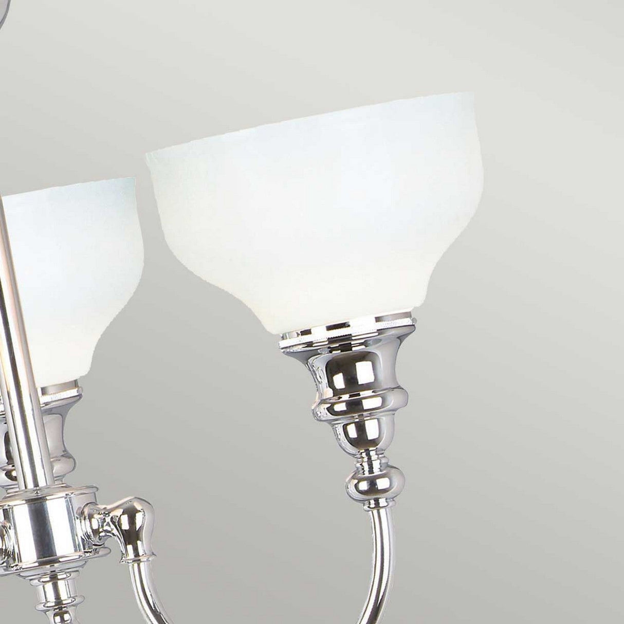 Close-up of the Cheadle 3 Light Semi Flush in polished chrome, featuring opal glass shades against a plain light background. The design showcases smooth curves and a reflective finish, combining elegance with simplicity.