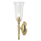 Introducing the Dryden-2 Wall Light in polished brass, featuring a sleek and elegant design with a tall, clear glass shade and an exposed bulb. Its circular base is polished to perfection, adding a timeless and classic touch to traditional interior lighting styles.