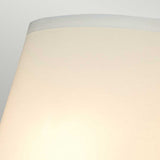Close-up of a simple cream-colored lampshade against a light gray background, reminiscent of the sleek design found in the Falmouth Wall Light - Gold/White Shade. The shade features a smooth, cylindrical shape with a slightly darker rim at the top, adding elegance similar to its gold finish.